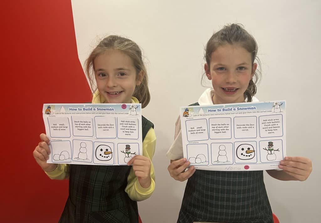 Two Girls Holding Their Tutoring Work Up