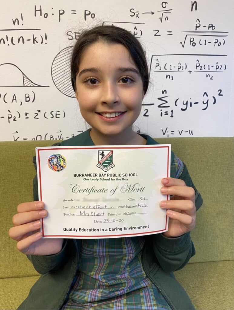 Primary student proudly presenting her award certificate