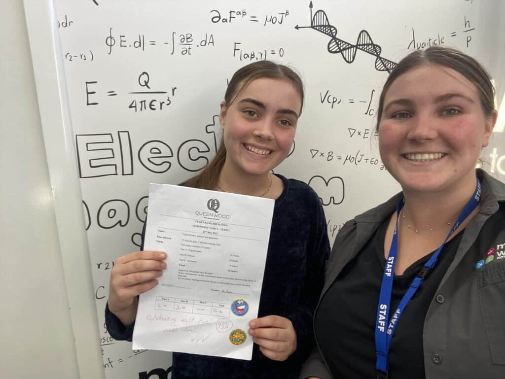 Happy high school student learning maths with an experienced tutor