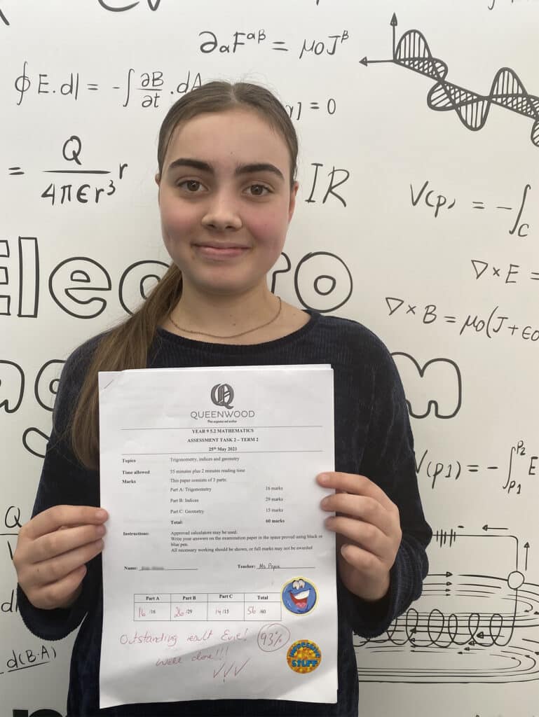Happy student holding her exam paper after completing a test