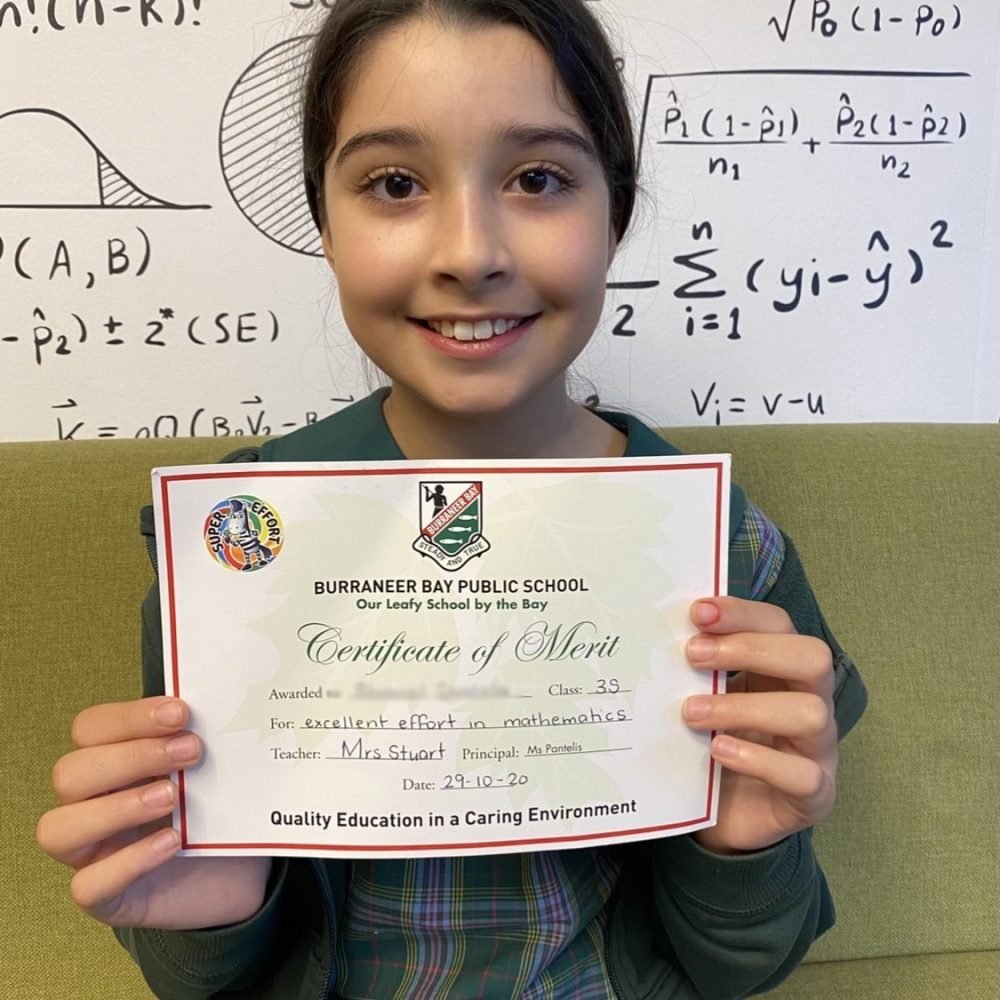 Primary student proudly presenting her award certificate