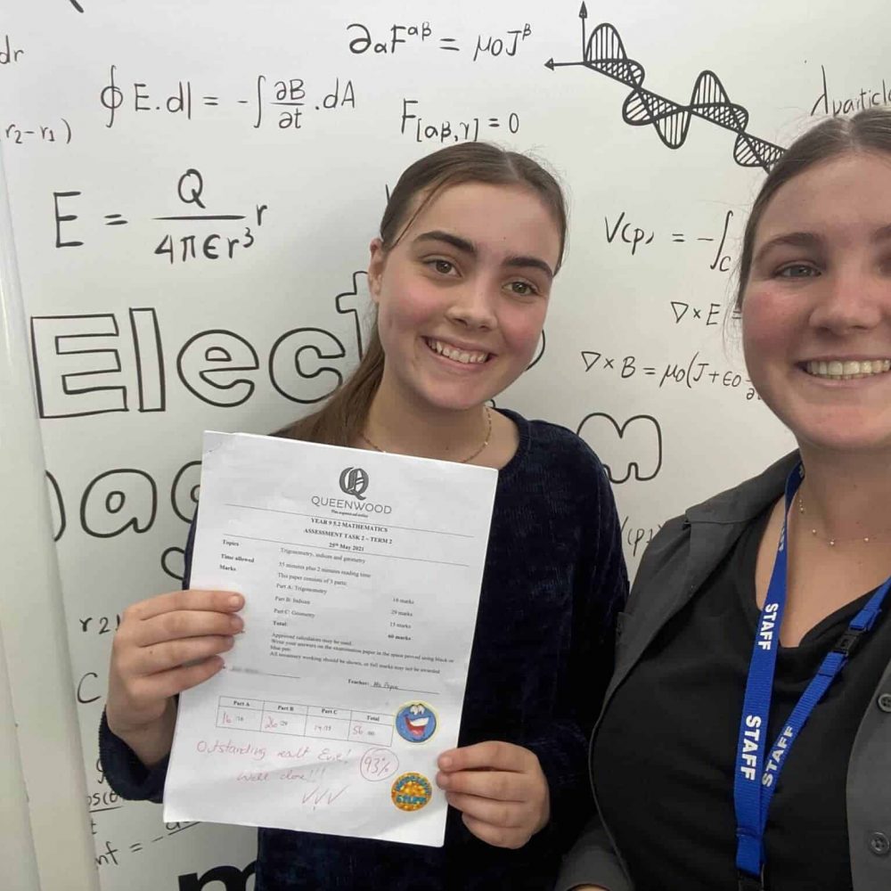 Happy high school student learning maths with an experienced tutor
