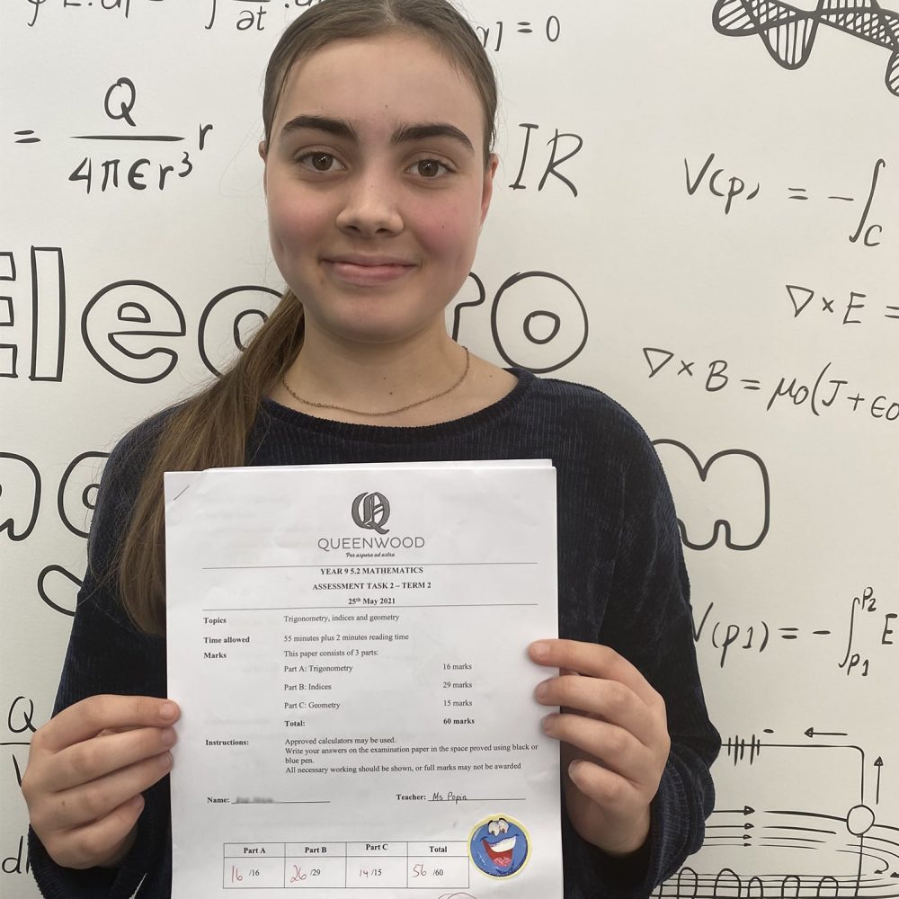 Happy student holding her exam paper after completing a test